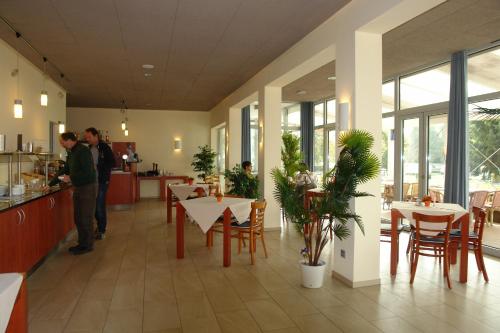 a restaurant with tables and chairs and people in a room at CAP Rotach in Friedrichshafen