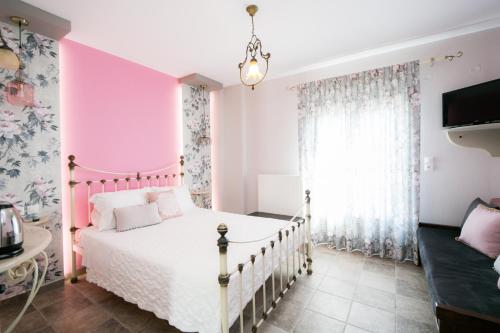 a pink and white bedroom with a bed at Guesthouse Iris in Tsagarada
