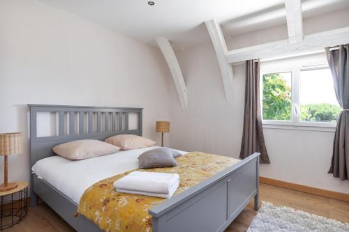 a bedroom with a bed with white walls and a window at Cahors - Lot - Les Lumières du Causse - Domaine en pierres blanches avec vue sur les causses in Bellefont-La Rauze