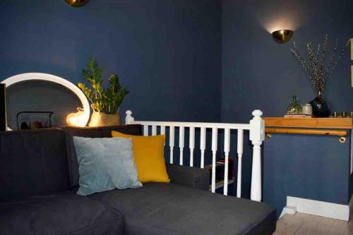 sala de estar con sofá y paredes azules en Cozy 1 Bedroom Home near the City Centre, en Edimburgo