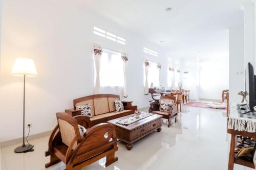 a living room with chairs and a couch and a table at Palem Kipas Homestay in Yogyakarta