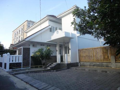 a white house with a fence in front of it at Palem Kipas Homestay in Yogyakarta