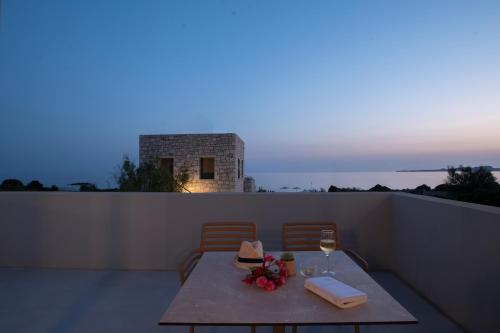 a table with a glass of wine on a balcony at Callisto Seaside Homes & Suites in Marathopolis