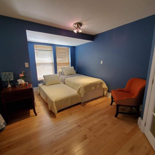 a blue bedroom with a bed and a chair at Garden 2 Storey House in Niagara Falls