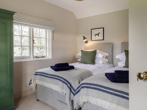 A bed or beds in a room at Beehives Cottage at Woodhall Estate