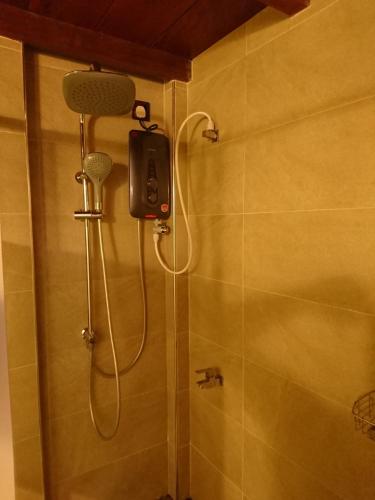 een douche met een douchekop in de badkamer bij Kaba Saradiel in Mawanella