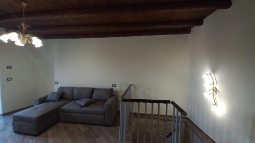 a living room with a couch and a staircase at La maison du château in Cremolino