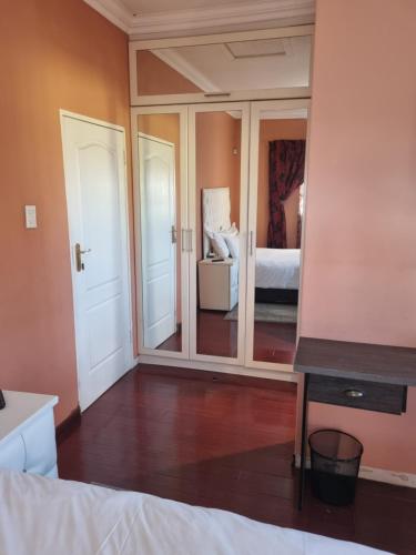a bedroom with a large mirror and a bed at Lalela House in Johannesburg