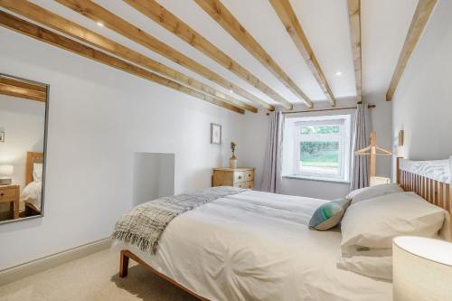 ein Schlafzimmer mit weißen Wänden und einem großen Bett in der Unterkunft Morlan Cottage in Newport