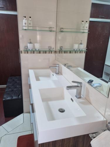 a bathroom with a white sink and a mirror at Lalela House in Johannesburg