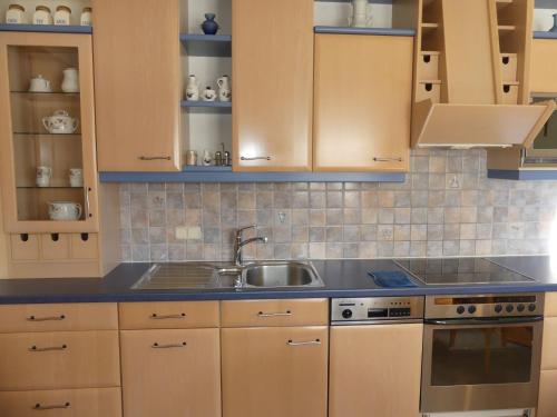 a kitchen with wooden cabinets and a sink at Apartment Stainer by Interhome in Neukirchen am Großvenediger