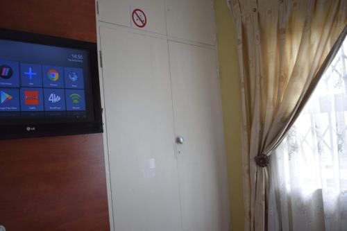 a white cabinet with a tv and a window at Lalela House in Johannesburg