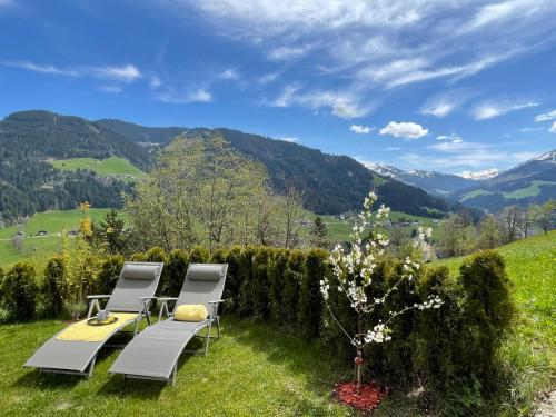a table and chairs on a hill with mountains in the background at Apartment Bergblick - WIL110 by Interhome in Oberau
