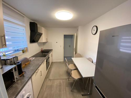 a kitchen with a table and a refrigerator at Strandnähe in Scharbeutz