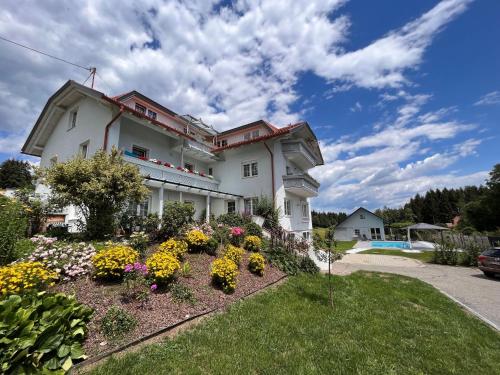 a large house with flowers in a yard at Apartment Frank-2 by Interhome in Feldkirchen in Kärnten