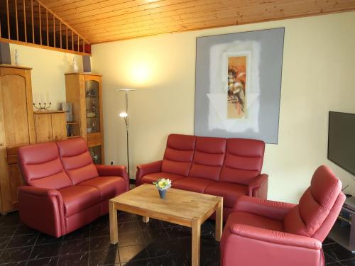 una sala de espera con sillas rojas y una mesa en Holiday Home Klipper by Interhome en Burhave