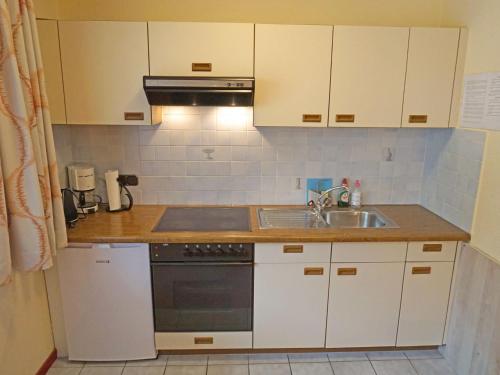 eine Küche mit weißen Schränken und einer Spüle in der Unterkunft Apartment Leiter-1 by Interhome in Sölden