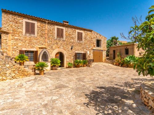 a stone house with a large driveway in front of it at Holiday Home Can Caubo by Interhome in S'Horta