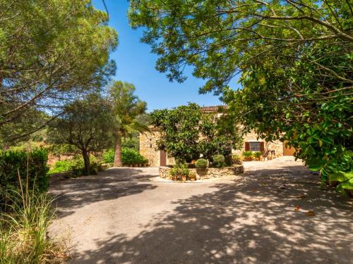 a driveway leading to a house with trees at Holiday Home Can Caubo by Interhome in S'Horta