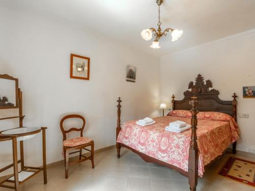 a bedroom with a bed and a table and a chair at Holiday Home Can Caubo by Interhome in S'Horta