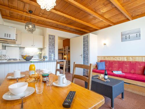 Il dispose d'une cuisine et d'un salon avec une table et des chaises en bois. dans l'établissement Apartment Lac Blanc 101 by Interhome, à Val Thorens