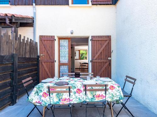 een tafel met stoelen en een tafelkleed op een patio bij Holiday Home Les Landaises-9 by Interhome in Lacanau-Océan