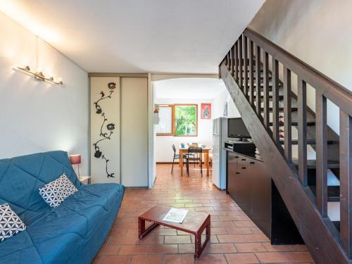 a living room with a blue couch and a staircase at Holiday Home Les Landaises-9 by Interhome in Lacanau-Océan