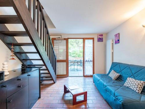 - un salon avec un canapé bleu et un escalier dans l'établissement Holiday Home Les Landaises-9 by Interhome, à Lacanau-Océan