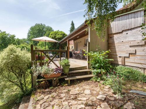 een huis met een houten veranda met een paraplu bij Holiday Home de Beaumont - NCA400 by Interhome in Carentan