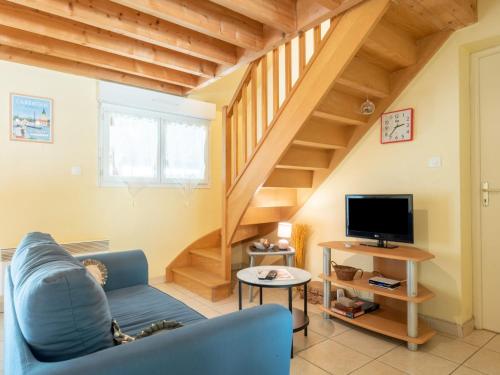 a living room with a blue couch and a television at Holiday Home de Beaumont by Interhome in Carentan