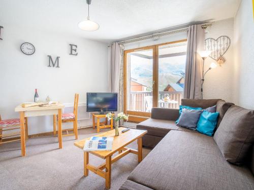 a living room with a couch and a table at Apartment Les Cimes de Caron-3 by Interhome in Val Thorens