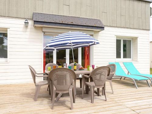 uma mesa com cadeiras e um guarda-sol num deque em Holiday Home Les mielles - SYL400 by Interhome em Denneville-Plage