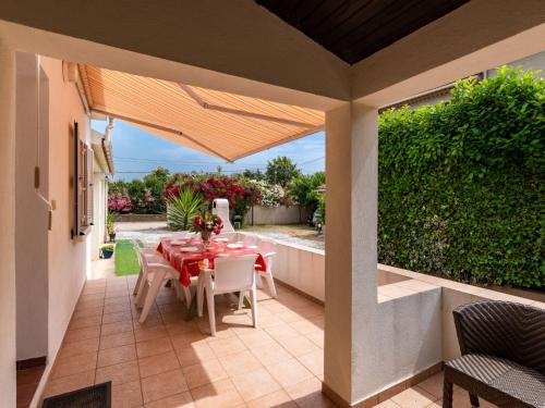 - un coin repas avec une table et des chaises sur la terrasse dans l'établissement Holiday Home Dami I-2 by Interhome, à Santa-Lucia-di-Moriani