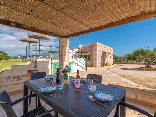 una mesa con una botella de vino en el patio en Holiday Home Son Ulari Petit by Interhome, en Can Picafort