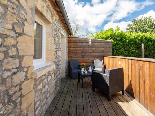 a patio with a table and chairs on a wooden deck at Holiday Home Le Repos by Interhome in Commes