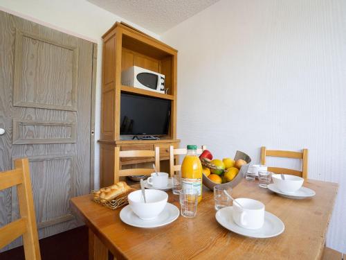 a wooden table with a bowl of fruit on it at Apartment Le Lac du Lou-2 by Interhome in Val Thorens