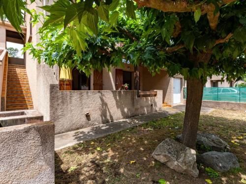 un arbre dans une cour à côté d'un bâtiment dans l'établissement Apartment Dami II-1 by Interhome, à Moriani-Plage