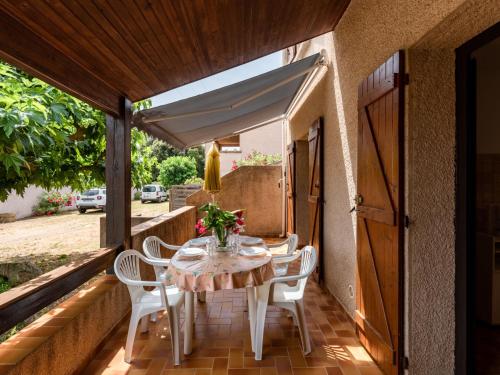 - une table et des chaises sur la terrasse couverte d'une maison dans l'établissement Apartment Dami II-1 by Interhome, à Moriani-Plage