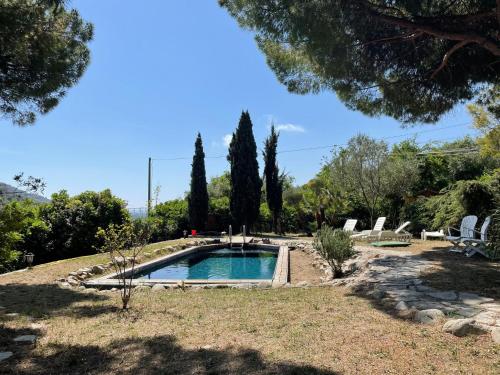 a swimming pool in a yard with chairs and trees at Holiday Home Villa La Vigna - TAZ175 by Interhome in Torrazza