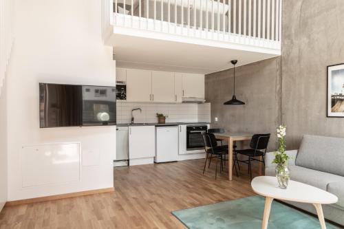 a kitchen and living room with a couch and a table at The More Hotel Västra Hamnen in Malmö