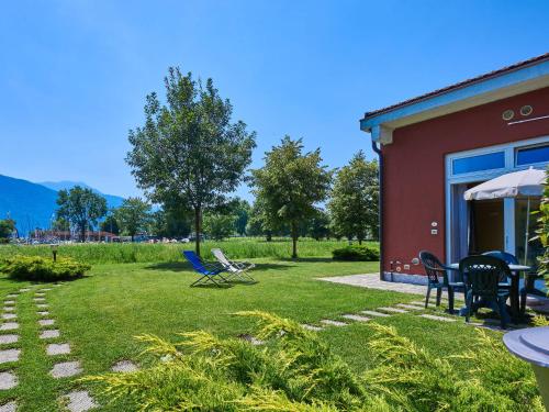 een tuin met stoelen en een tafel en een gebouw bij Holiday Home Gelsomino by Interhome in Consiglio di Rumo