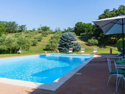 una piscina con sombrilla y algunas sillas y sombrilla en Holiday Home Le Querce by Interhome, en Fabrica di Roma