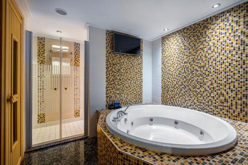 y baño grande con bañera y ducha. en Bera Alanya Hotel - Halal All Inclusive, en Konaklı