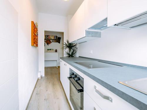 una cocina con armarios blancos y fregadero en Holiday Home Villetta ai Pini-2 by Interhome en Calceranica al Lago