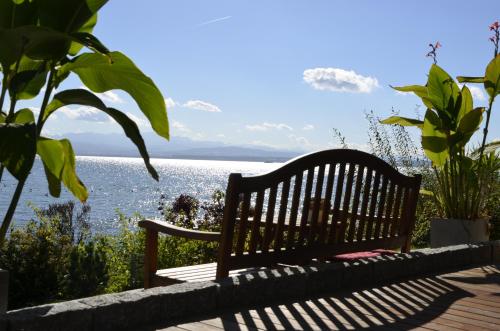 a bench sitting on a deck overlooking a body of water at Strandhaus Eberle in Immenstaad am Bodensee