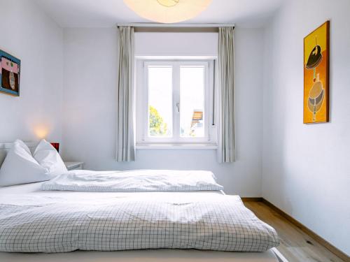 a white bedroom with a bed and a window at Holiday Home Villetta ai Pini-2 by Interhome in Calceranica al Lago