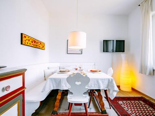 a white dining room with a table and a chair at Holiday Home Villetta ai Pini-2 by Interhome in Calceranica al Lago