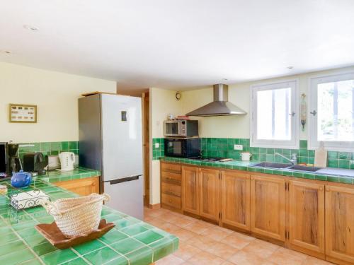 une cuisine avec des armoires en bois et un réfrigérateur blanc dans l'établissement Holiday Home Les Cotes by Interhome, à Saint-Martin-de-Castillon