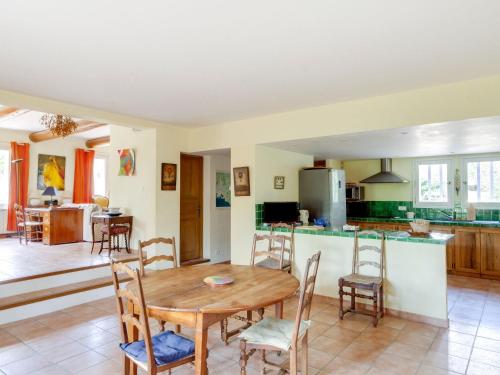 une cuisine et une salle à manger avec une table et des chaises en bois dans l'établissement Holiday Home Les Cotes by Interhome, à Saint-Martin-de-Castillon