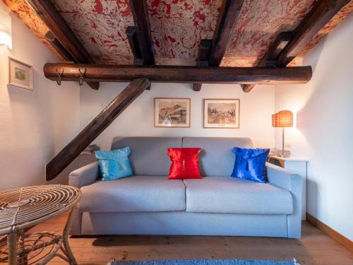 a living room with a blue couch with colorful pillows at Apartment Villa Margherita-3 by Interhome in Anduins